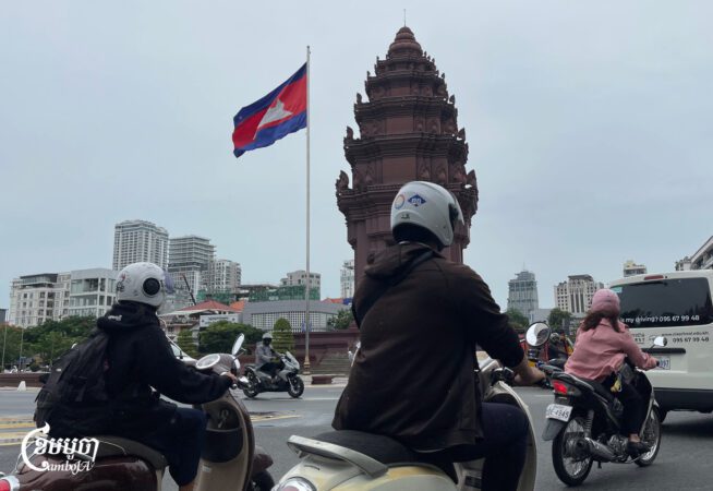 ពលរដ្ឋធ្វើដំណើរនៅរង្វង់មូលវិមានឯករាជ្យដែលមានដោតទង់ជាតិកម្ពុជា នាកណ្តាលរាជធានីភ្នំពេញ ថ្ងៃទី២១ ខែកក្កដា ឆ្នាំ២០២៥។ (ខេមបូចា/ព្រីង សំរាំង)