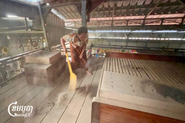 អ្នកស្រី ជីប រ៉ាន់ អាយុ ៧២ឆ្នាំ រស់នៅភូមិពោធិ៍ពីរ បោសលម្អងធូលី និងផេះលើផ្ទះបណ្តើរបានរៀបរាប់ប្រាប់បណ្ដើរថា ច្រើនឆ្នាំមកនេះ ពួកគាត់ត្រូវរស់នៅច្របូកច្របល់ជាមួយលម្អងធូលីស្រូវ និងផេះហុយចេញពីរោងម៉ាស៊ីន តុងភាព។ រូបភាពថតនៅថ្ងៃទី១០ ខែកញ្ញា ឆ្នាំ២០២៦។ ខេមបូចា/មាស ភារុណ)
