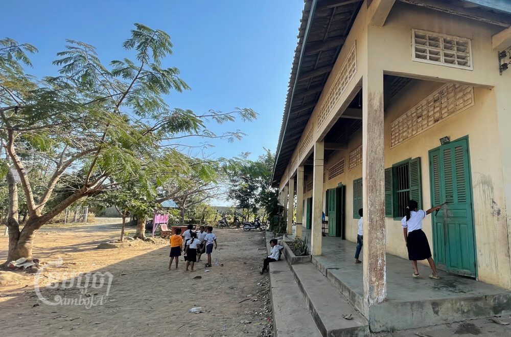 សិស្សានុសិស្ស កំពុងលេងនៅសាលាដែលរងផលប៉ះពាល់ដោយធូលីអំពៅចេញពីរោងចក្រស្ករអំពៅរបស់លោក លី យ៉ុងផាត់ នៅស្រុកឱរ៉ាល់ ខេត្តកំពង់ស្ពឺ។ រូបថតថ្ងៃទី១៨ ខែមករា ឆ្នាំ២០២២។ ខេមបូចា/ ឃួន ណារីម