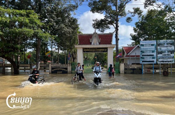 គ្រូ និងសិស្សានុសិស្សធ្វើដំណើរចេញពីវិទ្យាល័យមួយកន្លែងក្នុងស្រុកពួក ខេត្តសៀមរាប ដែលកំពុងរងការជន់លិចដោយជំនន់ទឹកភ្លៀងកាលពីថ្ងៃទី២៨ ខែកញ្ញា ឆ្នាំ២០២៦។ (ខេមបូចា/ប៉ា តុងចិន)