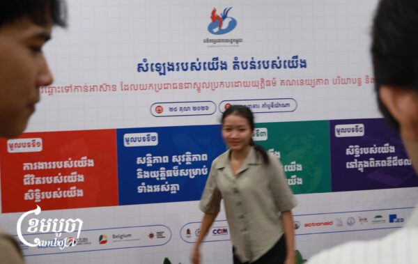 អ្នកចូលរួមកំពុងដើរទៅថតរូបមុខផ្ទាំងប៉ាណូនៅក្នុងវេទិកាប្រជាពលរដ្ឋកម្ពុជាឆ្នាំ២០២៦ នាថ្ងៃទី២៤ ខែតុលា ឆ្នាំ២០២៦។ (ខេមបូចា/ហុង សេរីហ្វុង)